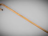 an old wooden walking stick with a black handle on a gray background
