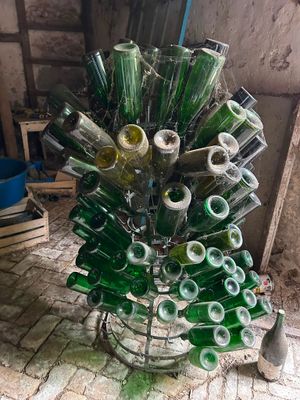 bottles are stacked on a wire rack in a room