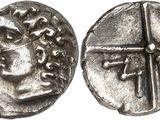a silver coin with an image of a man and a cross on it