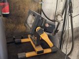 someone is working on a machine in a garage with a cup of coffee