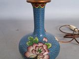un vase bleu orné d'une fleur, à côté d'un cordon