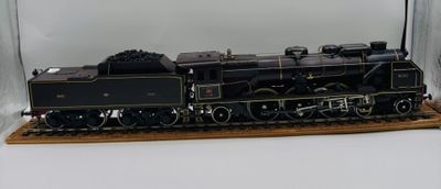 un train miniature dans une vitrine, posé sur une surface blanche
