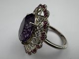 a close up of a ring with a purple stone on it