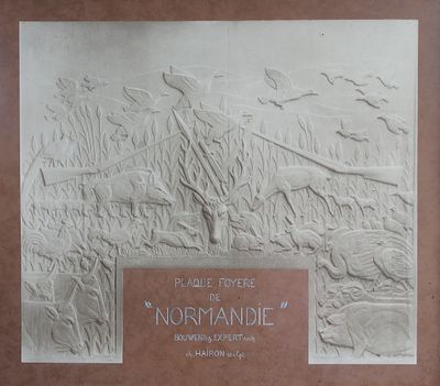 une plaque fixée au mur d'un immeuble, sur laquelle figure la photo d'un homme et d'un chien