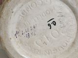 a close up of a vase on a white surface