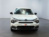 the front view of a white car parked in a white room
