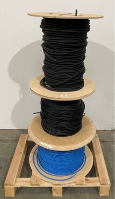 a close up of a stack of black and blue wires on a wooden stand