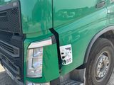 un camion vert dont le pare-chocs avant est cassé