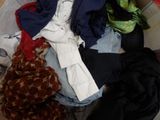 a pile of clothes that is on a bed