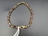 a close up of a bracelet with a tassel on a table