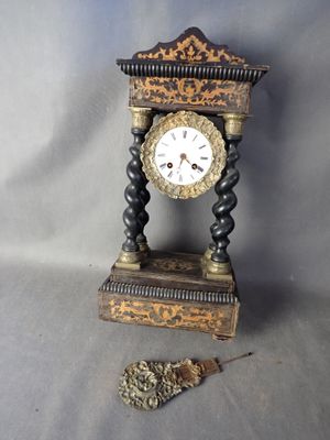 une horloge posée sur une table, à côté d'une chaîne