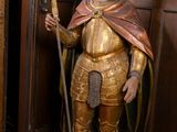 une statue représentant un homme armé d'une épée, dans une pièce