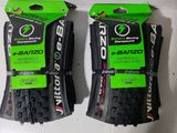 deux pneus de vélo noirs et verts sur une surface blanche