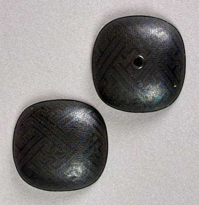 pair of black buttons on a white surface with a white background