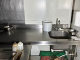 a large stainless steel kitchen with a sink and a counter