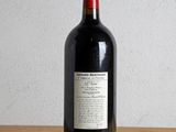 a bottle of red wine sitting on a wooden table