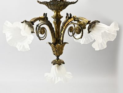 a gold chandelier with white flowers hanging from it