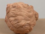 a clay sculpture of a man ' s head on a table