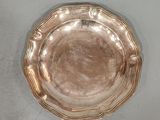une assiette en argent posée sur une table, sur fond blanc
