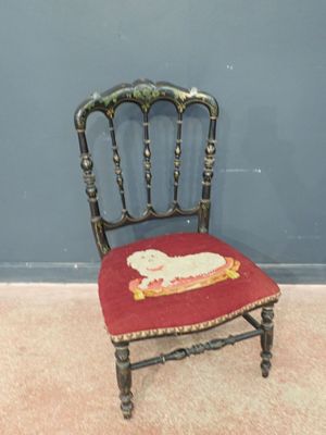 une petite chaise sur laquelle est assis un chat, devant un mur bleu