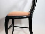 a black chair with a tan cushion on it