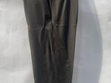 black leather pants hanging on a hanger on a white sheet