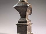 a bronze bust of a man on a pedestal