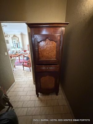 a tall wooden cabinet in the corner of a hallway