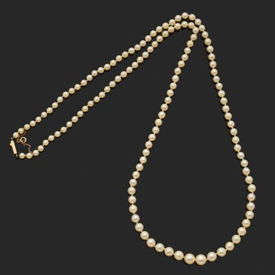 un collier de perles avec un fermoir en or