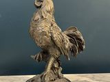 statue of a rooster on a marble base on a table