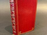 a red book sitting on top of a table next to a gray wall