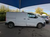 a white van parked in a parking lot under a blue umbrella