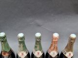 six bottles of wine are lined up in a row on a table