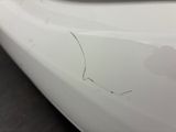 a close up of a white car with a hole in the side of it