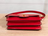 a red purse sitting on top of a wooden table