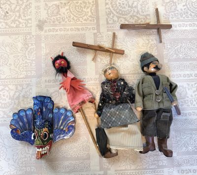 three figurines of people sitting on a wall