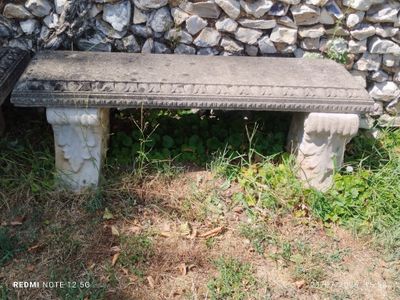 un banc en pierre posé devant un mur en pierre