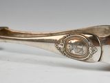 an image of a silver cuff with a metal clasp on a white surface