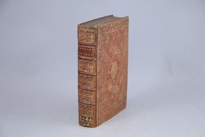 un vieux livre posé sur une table à côté d'un fond blanc