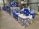 Des cartons de papier toilette sont empilés sur des palettes dans un entrepôt