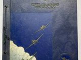 un vieux livre avec une couverture bleue et une illustration représentant des avions volant dans le ciel