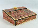 an ornate red and gold box with a gold lion on top