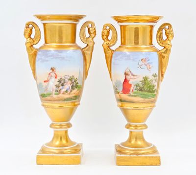 deux vases en or ornés de peintures, posés sur une table
