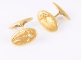 an image of a pair of gold cufflinks on a white background
