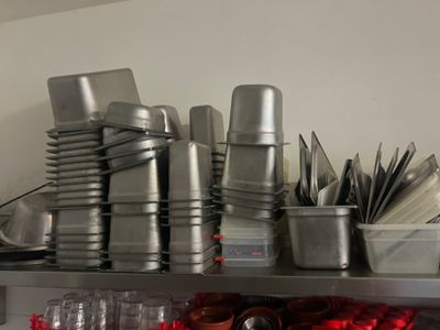 many cups and pans on the shelf in the kitchen