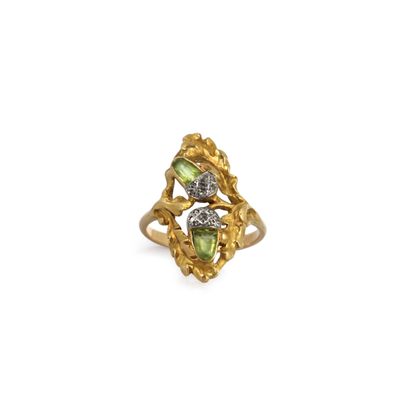 a close up of a gold ring with two green stones