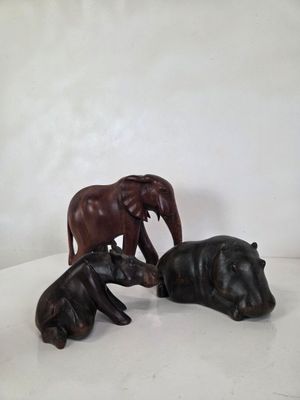 trois figurines d'éléphants et un hippopotame sur un fond blanc