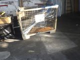a cage in the middle of a room with a bike in the background