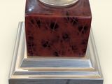 a red marble clock on a silver stand
