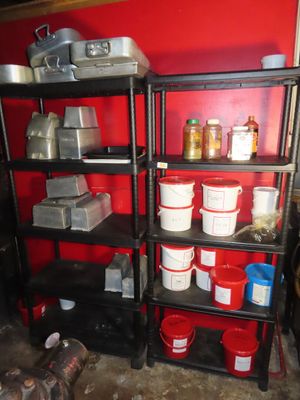 many buckets and pans on a shelf in a room